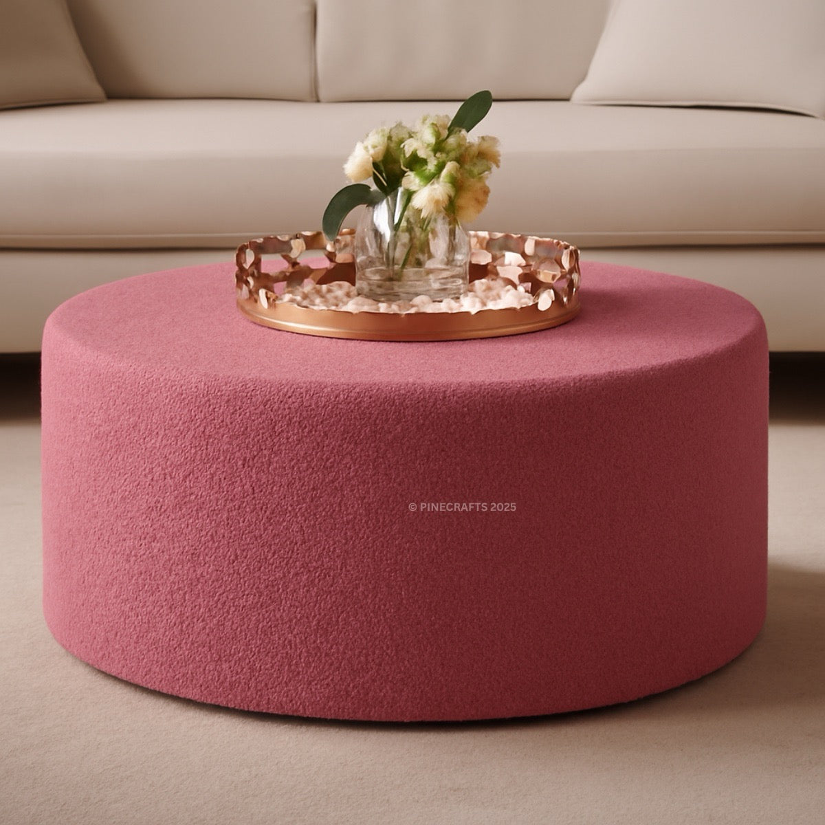 Pink ottoman with a decorative tray and flowers on a beige sofa background